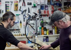 2 Mechanics working on a bike in the shop